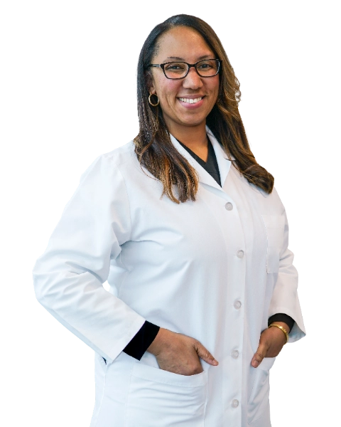 VTC_DrGreen_optimized (2) Professional headshot of Dr. Tamara Green wearing a white lab coat over dark scrubs and glasses, smiling confidently against a black background. This official clinical portrait represents a healthcare provider ready for patient consultations and medical practice.